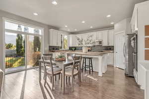 Dining room with wood finished floors and recessed lighting