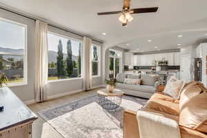 Living room with arched walkways, a ceiling fan, baseboards, and recessed lighting