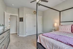 Bedroom with light carpet, baseboards, a closet, and ceiling fan