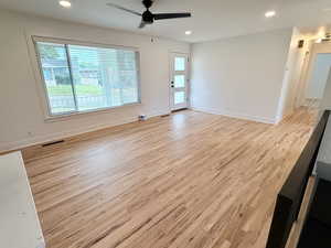 Unfurnished room with wood finished floors, a ceiling fan, recessed lighting, and baseboards