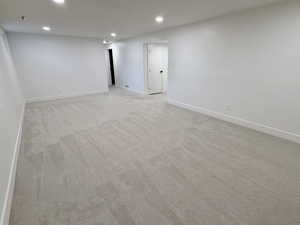 Spare room with recessed lighting, light colored carpet, and baseboards