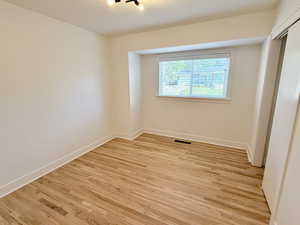 Unfurnished room with light wood finished floors and baseboards