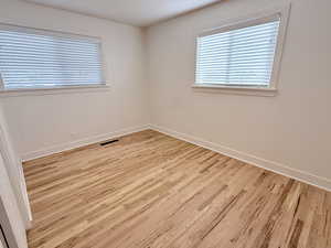 Unfurnished room with light wood-type flooring and baseboards