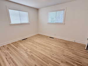 Empty room with light wood finished floors and baseboards