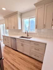 Kitchen with dishwasher, a sink, light wood finished floors, healthy amount of natural light, and recessed lighting