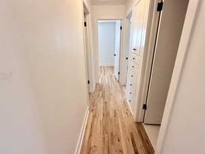 Hall featuring light wood-style flooring and baseboards