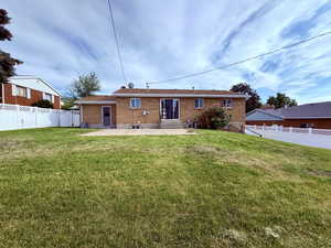 Rear view of house featuring entry steps, a patio, and brick siding