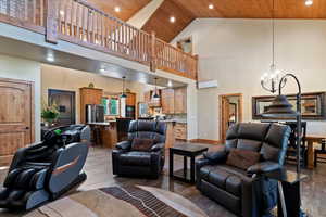 Living area with wood ceiling, a high ceiling, a chandelier, recessed lighting, and light wood finished floors