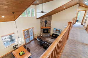 Living area with wood ceiling, high vaulted ceiling, recessed lighting, ceiling fan, and a chandelier