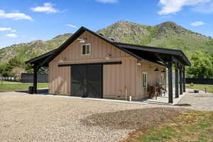 View of outdoor structure featuring a mountain view, an outbuilding, and fence