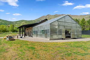 Rear view of house featuring an exterior structure, a mountain view, and an outbuilding