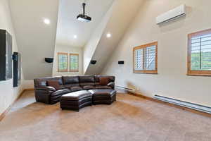 Living room with baseboard heating, a wall mounted AC, plenty of natural light, recessed lighting, and high vaulted ceiling