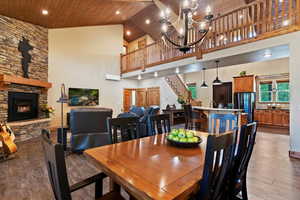 Dining area featuring wood finished floors, high vaulted ceiling, wooden ceiling, stairs, and a chandelier
