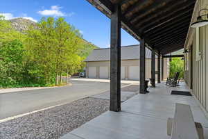 View of patio with an outbuilding, a garage, and a mountain view