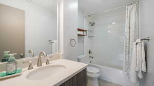 Full bathroom with toilet, shower / bath combination, and vanity