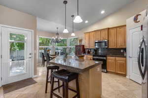 Kitchen with black range with electric stovetop, stainless steel microwave, a sink, a chandelier, and plenty of natural light