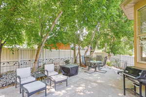 Fenced backyard with a patio area, a grill, and outdoor dining area
