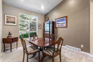 Dining room featuring light colored carpet, baseboards, recessed lighting, and lofted ceiling