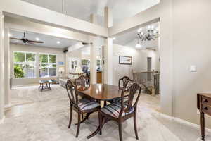 Dining space with light colored carpet, baseboards, ceiling fan, a chandelier, and recessed lighting