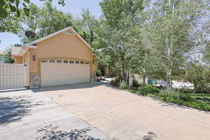 View of front of home with stone siding, stucco siding, an attached garage, and driveway