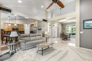 Living room featuring ceiling fan, light colored carpet, lofted ceiling, recessed lighting, and baseboards