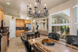 Dining area featuring a high ceiling, recessed lighting, a chandelier, and light tile patterned floors