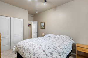 Bedroom featuring light colored carpet and a closet