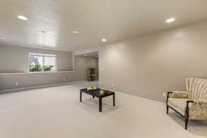 Unfurnished room with light colored carpet, recessed lighting, baseboards, and a textured ceiling
