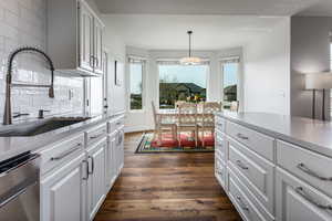 Kitchen with a sink, dark wood-style floors, dishwasher, decorative backsplash, and plenty of natural light