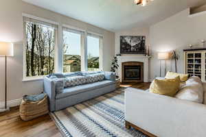 Family room with wood floors, vaulted ceiling and a healthy amount of sunlight.