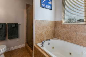 Bathroom featuring a jetted tub, and separate tiled shower.
