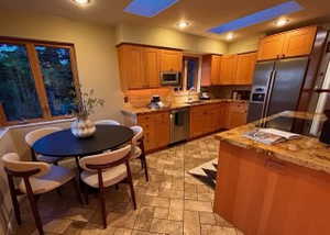 Kitchen with appliances with stainless steel finishes, stone tile flooring, a sink, recessed lighting, and light stone countertops