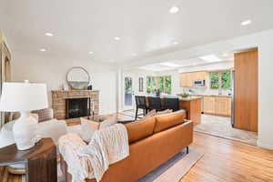 Living room with light wood-style floors, recessed lighting, a fireplace, and baseboards