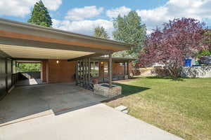 View of vehicle parking featuring a carport and driveway