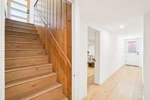Stairway with wood finished floors and recessed lighting