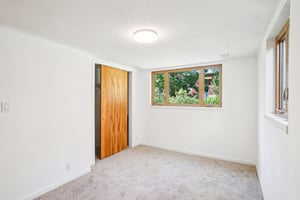 Carpeted spare room featuring baseboards