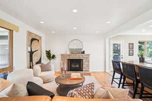Living room with a fireplace, wood finished floors, and recessed lighting