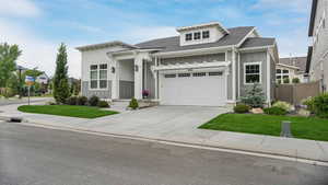 View of front of home featuring board and batten siding, a garage, driveway, and a shingled roof