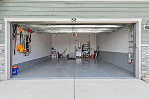 Finished garage with painted walls,  ceil professional rack storage, epoxy flooring, insulated garage door and central vacuum unit