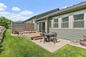 Secluded back yard with a deck and concrete patio