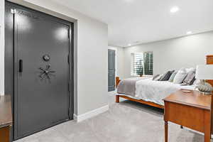 Basement bedroom featuring light colored carpet, recessed lighting, Liberty walk-in fire resistant safe room