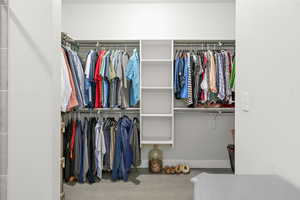 Spacious walk-in closet with light engineered hardwood flooring