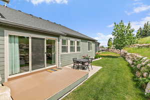 View of secluded back yard with a deck and concrete patio