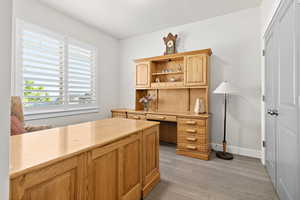 Office or bedroom #2 with light engineered hardwood flooring and plantation shutters