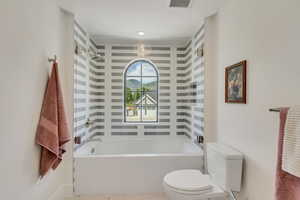 Bathroom featuring toilet and shower / washtub combination