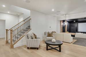Living room with light wood-style floors, stairs, and recessed lighting