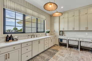 Kitchen with stone tile floors, decorative light fixtures, light countertops, and recessed lighting