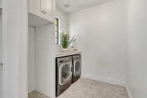 Laundry room with washer and clothes dryer and cabinet space