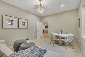 Dining room featuring carpet flooring, a chandelier, and recessed lighting