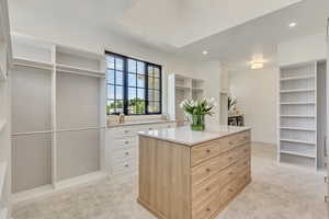Spacious closet featuring light colored carpet and washing machine and dryer